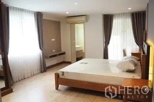 Condominium for rent in Pathum Wan, Bangkok - Large master bedroom with dual-aspect windows and entry to ensuite bathroom.