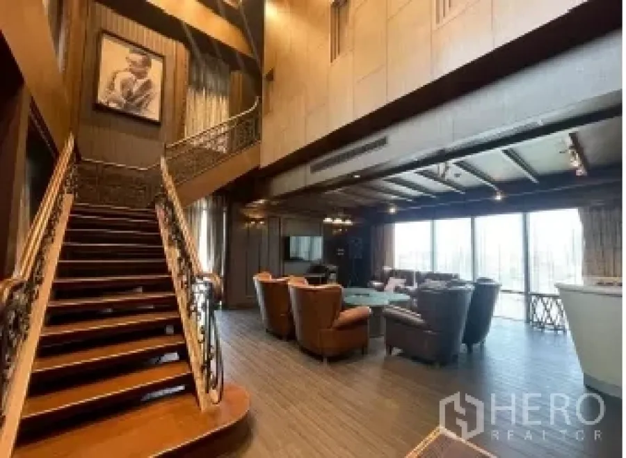 พื้นที่ขายปลีก ให้เช่า - ภายในร้านค้าพื้นที่โล่งเพดานสูงสองชั้น บันไดไม้ ชุดโซฟา แชนเดอเลียร์ และผนังกระจกสูงจรดเพดาน