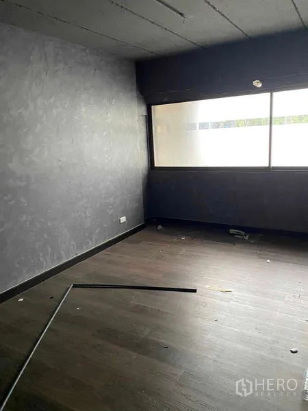 อาคารพาณิชย์ ให้เช่าในHuai Khwang, Bangkok - ห้องชั้นบนโล่ง หน้าต่างฟรอสต์ ผนังปูนสีเทาและพื้นไม้เข้ม