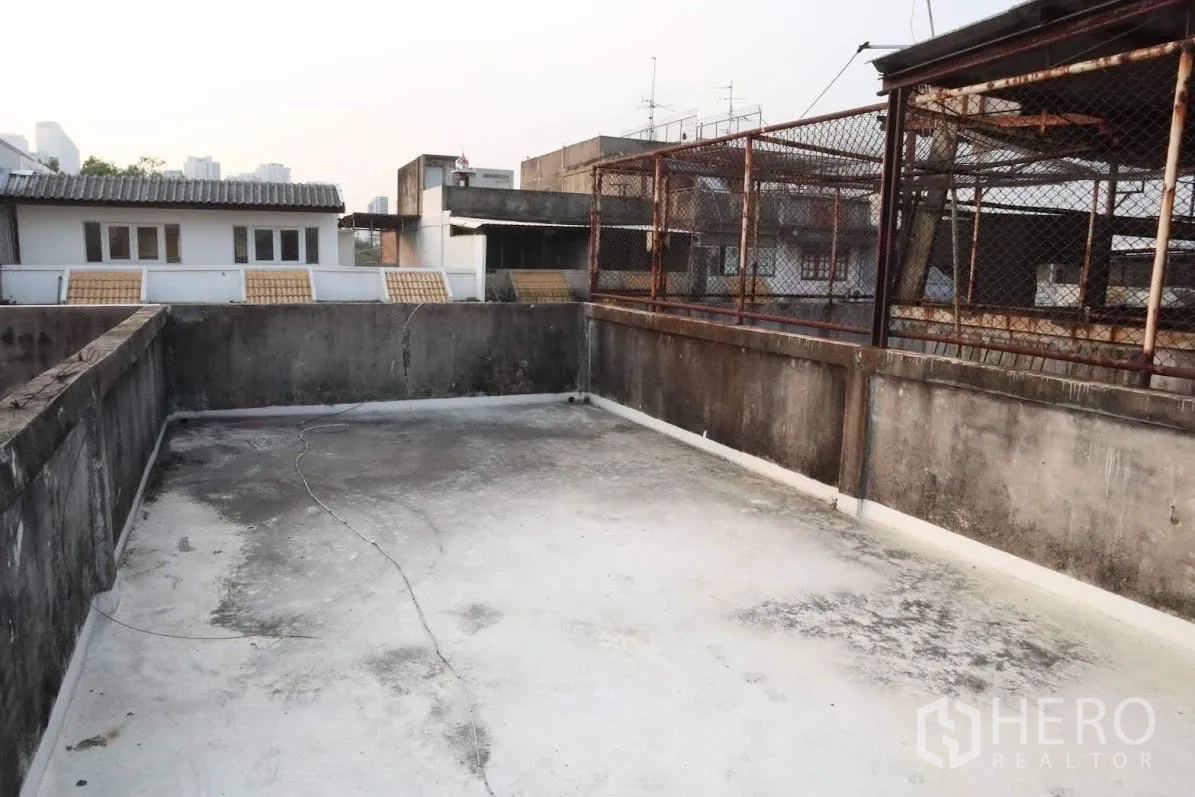 Shophouse for sale in Huai Khwang, Bangkok - Open concrete rooftop terrace on a Huai Khwang shophouse with surrounding urban views.