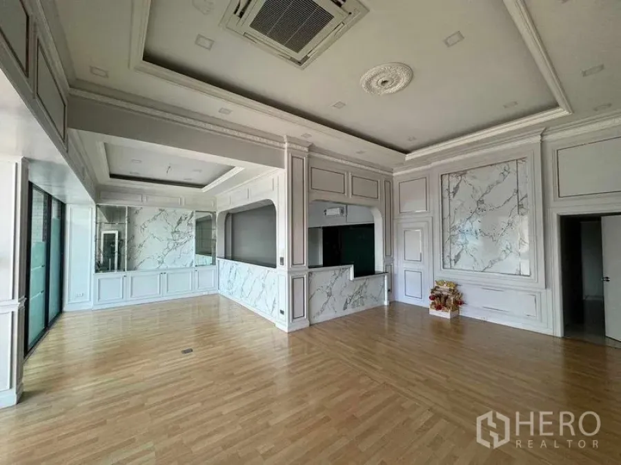 Office Space for rent in Prawet, Bangkok - Elegant open office with coffered ceilings, marble wall panels and light wood flooring.