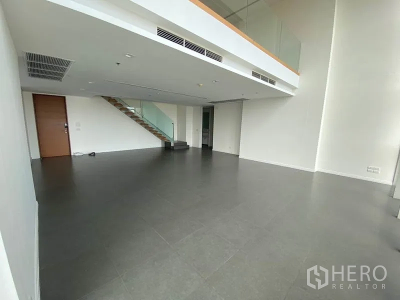 คอนโด ให้เช่าหรือขายในKhlong San, Bangkok - พื้นที่นั่งเล่นสองชั้นโล่งโปร่ง มีชั้นลอยและพื้นกระเบื้องสีเทา