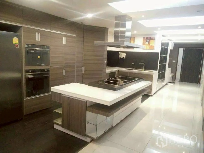 公寓 for rent or sale in Watthana, Bangkok - 现代厨房设中岛灶台、不锈钢烟机、嵌入式烤箱与高柜。