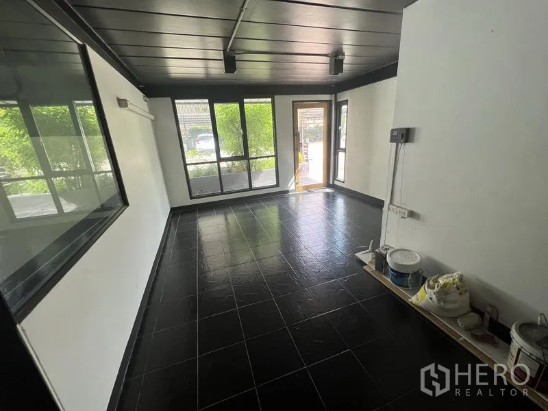零售空间 出租在Watthana, Bangkok - 附加房间，黑色地砖与大窗，可作办公室或备餐区。