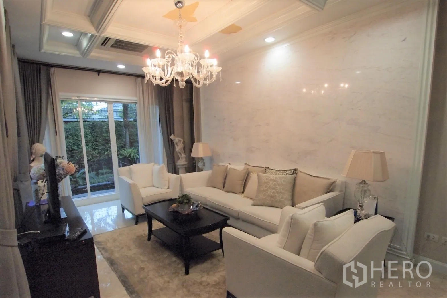 Detached House for rent or sale in Saphan Sung, Bangkok - Elegant living room with white sofas, chandelier and garden view