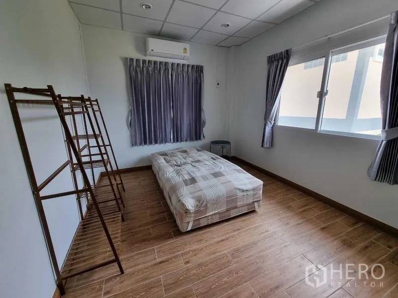 独立式住宅 出租在Mueang Nonthaburi, Nonthaburi - 宽敞卧室，大窗、空调与独立衣架。
