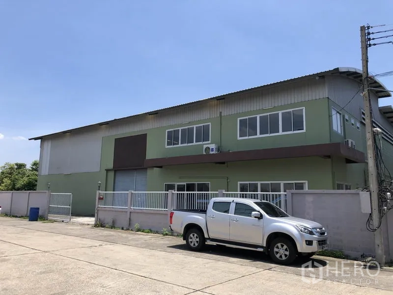 工厂 出租在Pathum Thani - 工厂正面，围栏、停车位与装卸卷闸门清晰可见