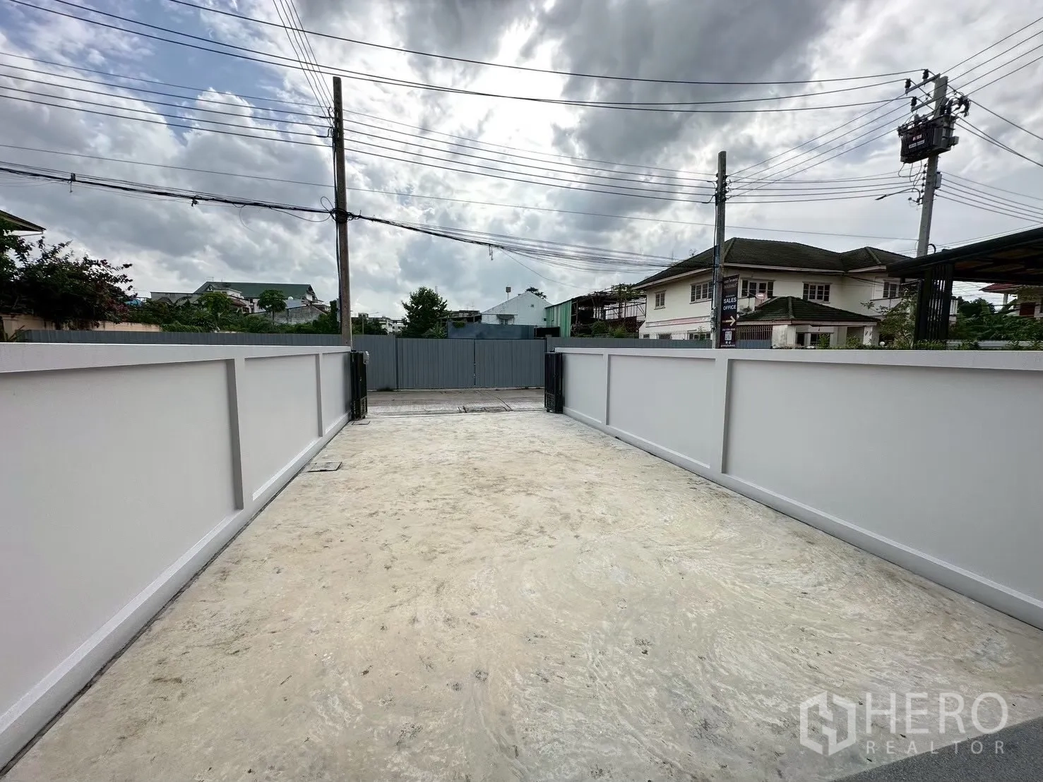 สำนักงานที่บ้าน for rent in Lat Phrao, Bangkok - ลานหน้าบ้านมีรั้วรอบ พื้นคอนกรีตกว้างสำหรับจอดรถหลายคัน.