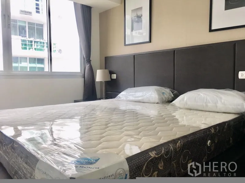 คอนโด ให้เช่าในKhlong Toei, Bangkok - ห้องนอนพร้อมเตียงขนาดใหญ่ หัวเตียงบุนุ่ม และหน้าต่างรับแสง