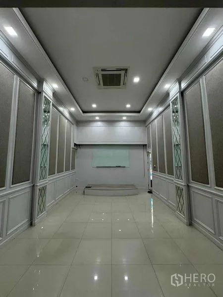 Office Space for rent in Prawet, Bangkok - Long conference room with recessed lighting, paneled walls, whiteboard and glossy tile floor.