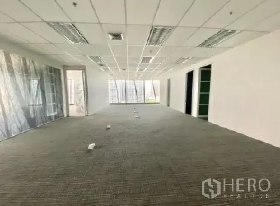 Office Space for rent - Long open workspace with carpet, ceiling lights, glass partitions and multiple floor boxes for cabling.