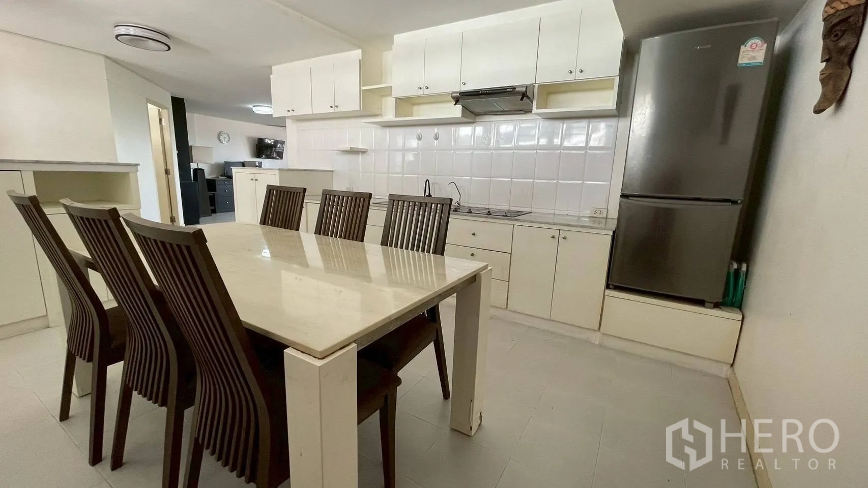 Condominium for sale in Wang Thonglang, Bangkok - Dining area beside full-height cabinets and a stainless refrigerator.