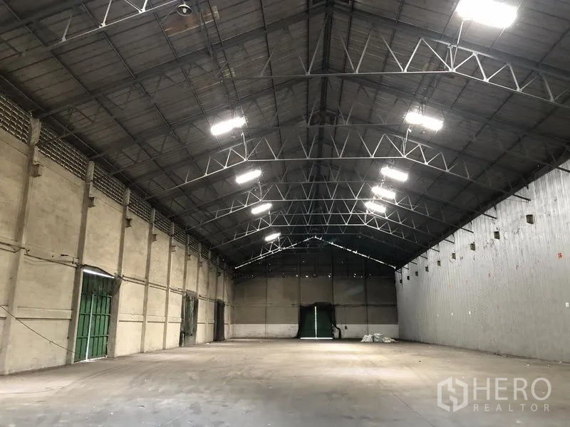 货栈 出租在Mueang Pathum Thani, Pathum Thani - 仓库内部空间开阔，钢桁架高顶，照明充足，多处出入口。