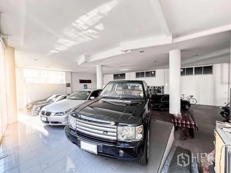 展厅 出租或出售在Bangkok Yai, Bangkok - 展厅区域陈列SUV与轿车，紧邻落地玻璃立面。