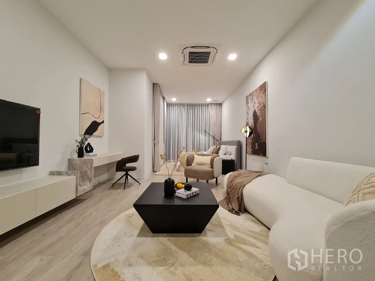 独立式住宅 出租在Saphan Sung, Bangkok - 纵深客厅，多组沙发、书桌与嵌入式空调。