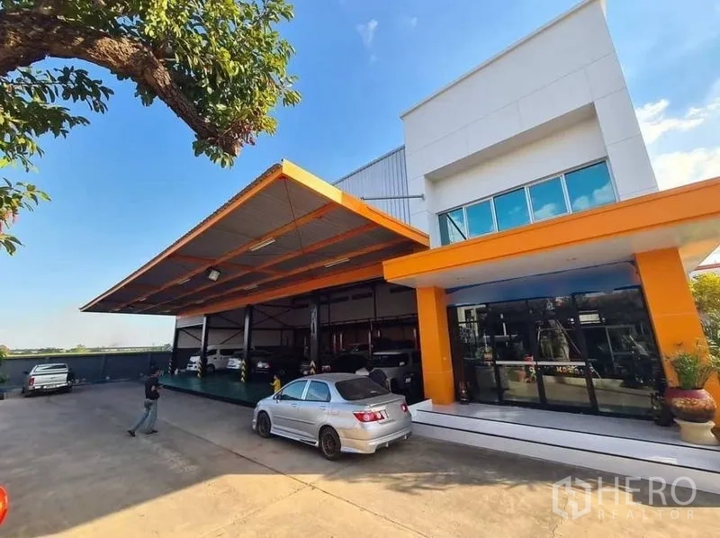 คลังสินค้า ให้เช่าในThanyaburi, Pathum Thani - ภายนอกโกดังสมัยใหม่ หลังคาโครงสร้างสีส้ม ออฟฟิศกระจก และลานจอดรถกว้าง