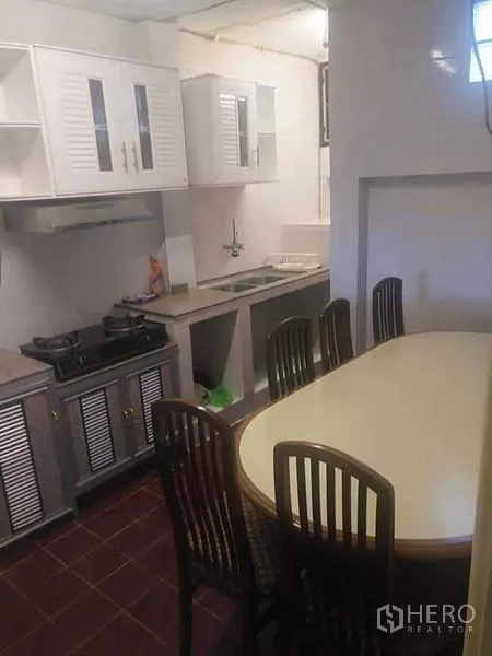 ทาวน์เฮาส์ ให้เช่า - ครัวพร้อมเตาแก๊ส ตู้เก็บของสีขาว และโต๊ะทานอาหารพร้อมเก้าอี้