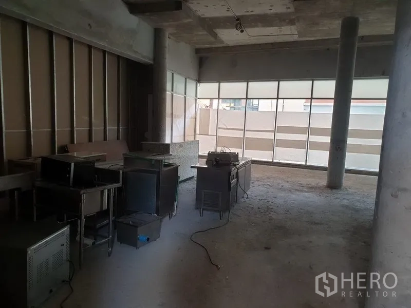 พื้นที่ขายปลีก ให้เช่าในKhlong Toei, Bangkok - พื้นที่ร้านค้ายังไม่ตกแต่ง เพดานคอนกรีต เสาและกระจกหน้าร้านบานใหญ่ มีอุปกรณ์วางอยู่ในห้อง
