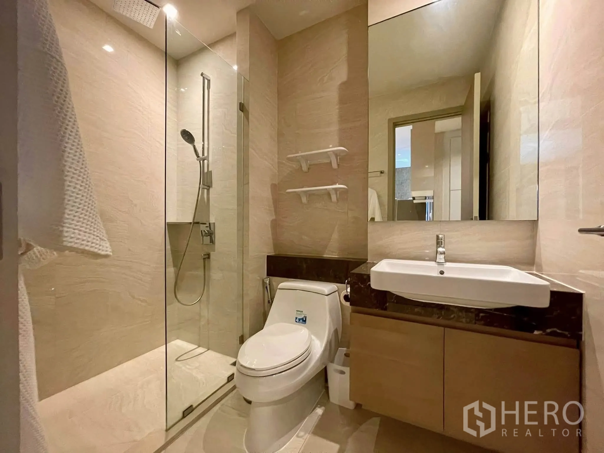 Condominium for rent in Bang Rak, Bangkok - Modern bathroom with glass shower, rain head, vanity and toilet.