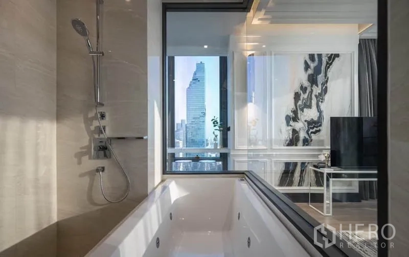 Condominium for rent in Bang Rak, Bangkok - Luxury bathroom with deep soaking tub and shower looking through glass to the city skyline.