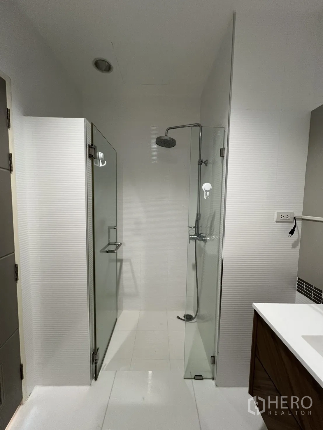 Condominium for rent in Bang Kapi, Bangkok - Master bedroom with open wardrobe shelving and a sliding door to the balcony.