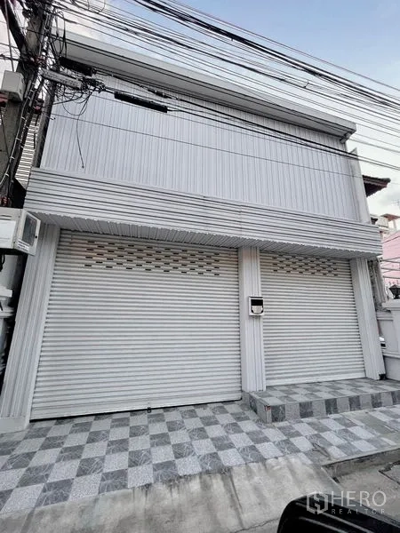 ทาวน์เฮาส์ ให้เช่าในHuai Khwang, Bangkok - ด้านหน้าทาวน์เฮ้าส์สองชั้น ม่านเหล็กม้วน และลานกระเบื้องหน้าบ้าน