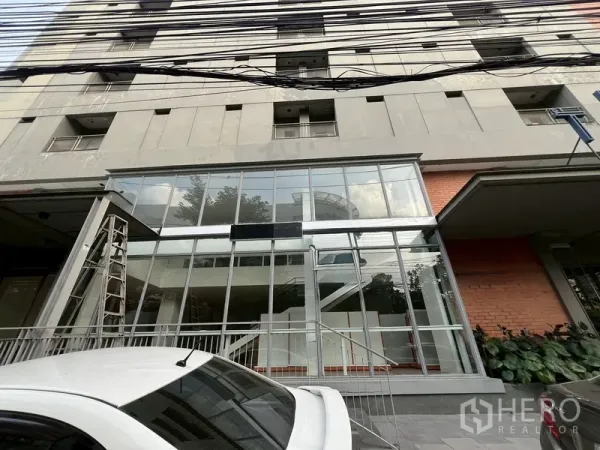 零售空间 出租在Watthana, Bangkok - 一层玻璃门面建筑外观，带台阶入口和前方停车位