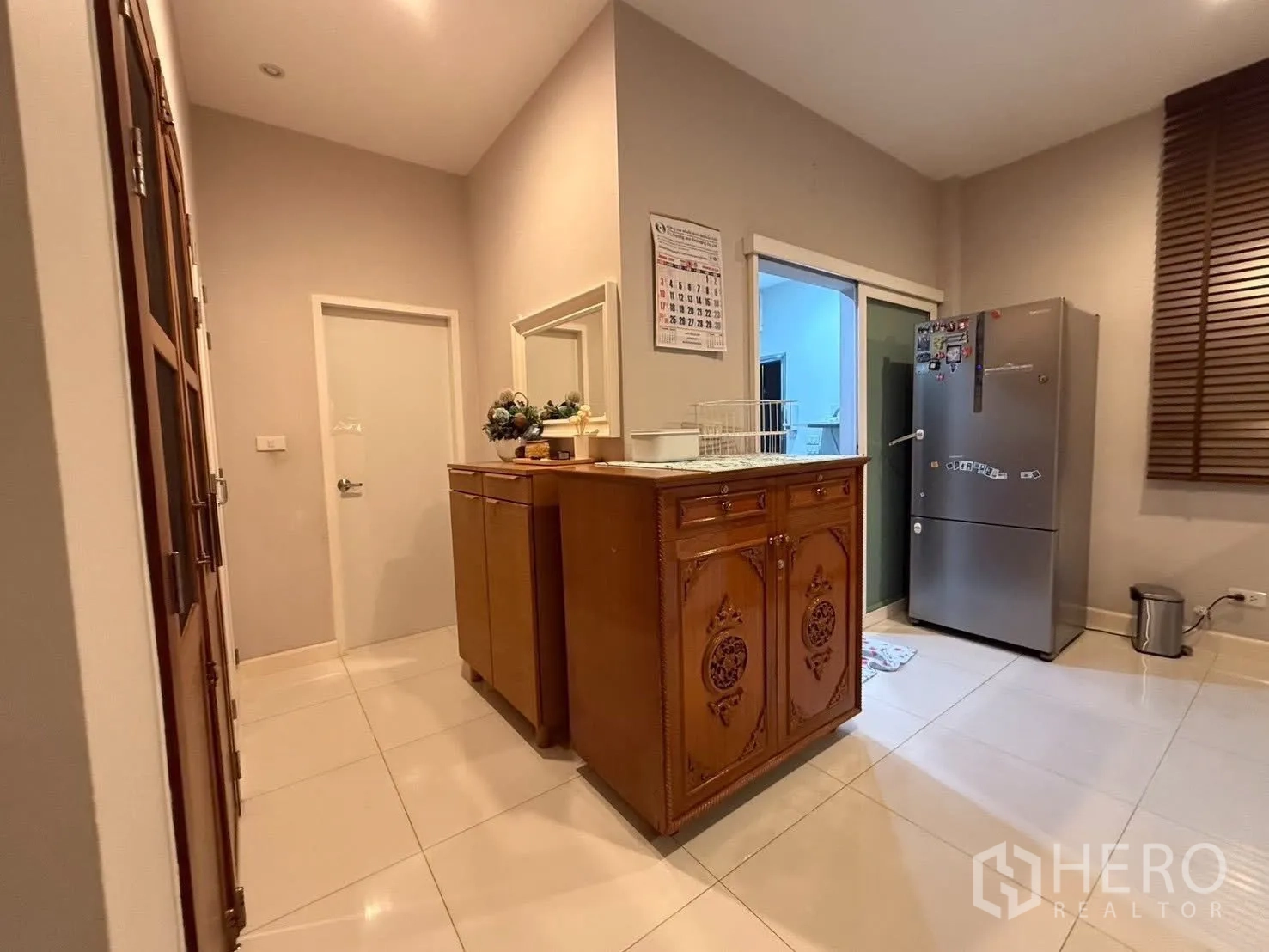 Detached House for rent in Bang Na, Bangkok - Hallway by the kitchen with storage cabinets and access doors.
