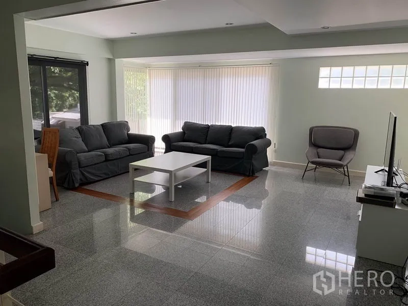 ทาวน์เฮาส์ ให้เช่าในKhlong Toei, Bangkok - ห้องนั่งเล่นสว่าง โซฟา โต๊ะกลาง ชั้นวางทีวี และม่านบังแสงแบบเต็มผนัง