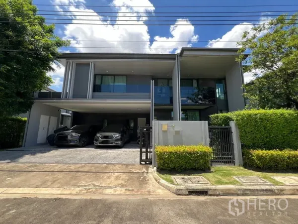 Detached House for rent in Bang Kapi, Bangkok - Front exterior view showing sleek facade with glass balcony and wide driveway.