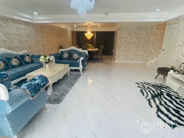 คอนโด ให้เช่าหรือขายในWatthana, Bangkok - ห้องนั่งเล่นและรับประทานอาหารแบบโอเพ่น พร้อมโซฟาสีน้ำเงิน พื้นลายหินอ่อน และโคมแชนเดอเลียร์