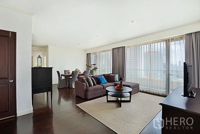 คอนโด ให้เช่าในKhlong San, Bangkok - ห้องนั่งเล่นกว้าง โซฟาเซกชันนอล ตู้ทีวี และกระจกสูงจรดเพดาน