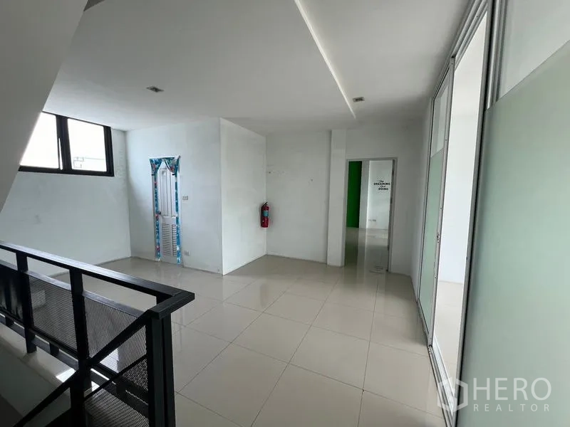 Warehouse for rent in Bang Phli, Samut Prakan - Upper landing with window, staircase and corridor leading to office rooms with glossy tiles.