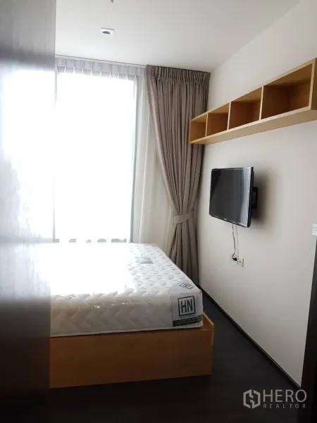 คอนโด ให้เช่าหรือขายในWatthana, Bangkok - ห้องนอนอบอุ่น เตียงยกพื้น ทีวีติดผนัง และหน้าต่างบานใหญ่พร้อมผ้าม่าน