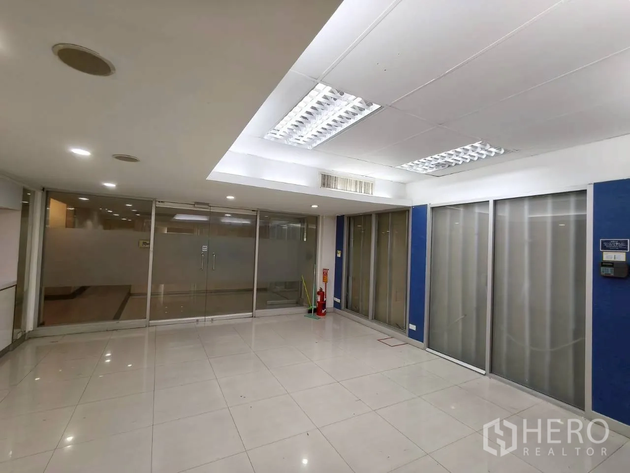 ออฟฟิศ for rent in Chatuchak, Bangkok - โซนประชุมสว่างสดใส มีกระจกฝ้า ผนังสีฟ้า และไฟเพดาน.