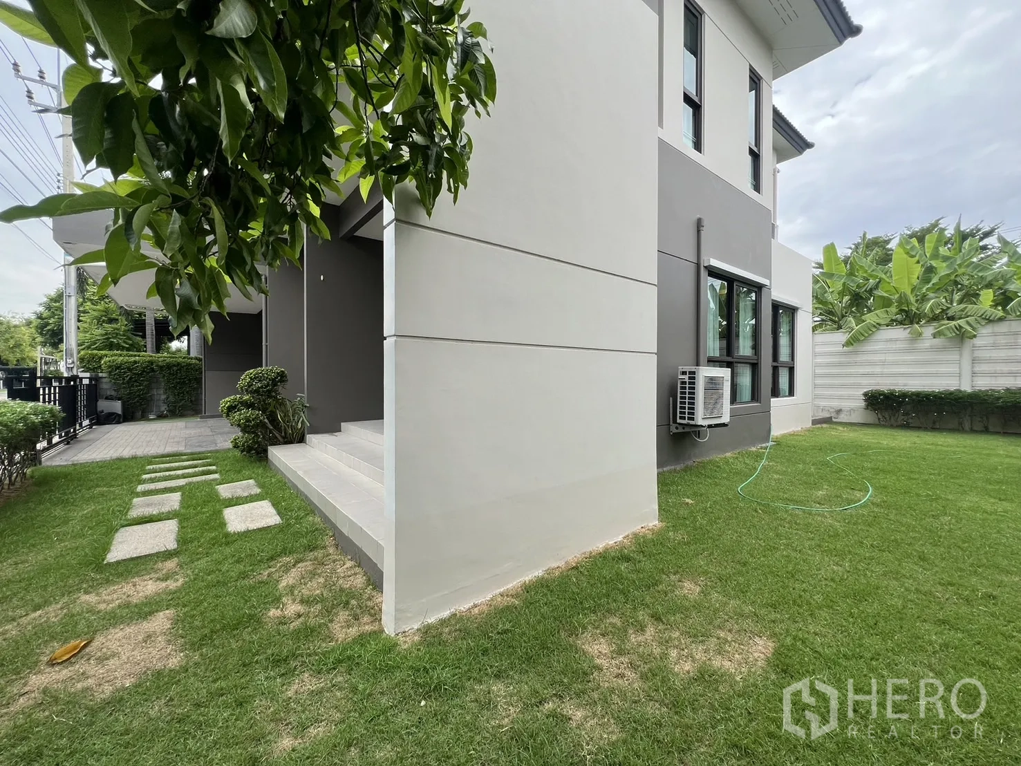 บ้าน ให้เช่าหรือขายในPrawet, Bangkok - มุมตัวบ้านพร้อมสนามหญ้าและบันไดหน้าบ้าน