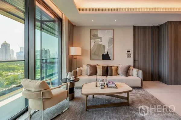 Condominium for rent or sale in Pathum Wan, Bangkok - Cozy lounge area by the balcony overlooking greenery and Bangkok skyline.