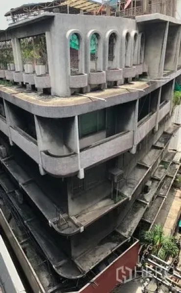 店屋 出租在Bangkok - 多层商铺外立面，混凝土结构，带弧形阳台与拱形窗，位于Nana一带。