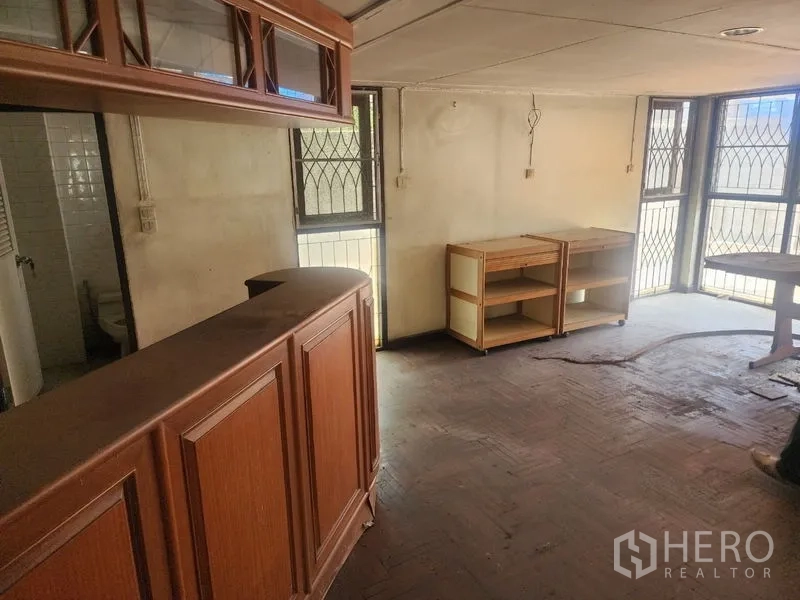 Detached House for rent in Watthana, Bangkok - Living area featuring a wooden bar and built-in cabinets with parquet flooring.