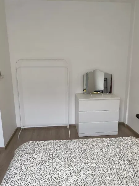 联排别墅 出租在Prawet, Bangkok - 简约卧室一角，五斗柜与衣架。