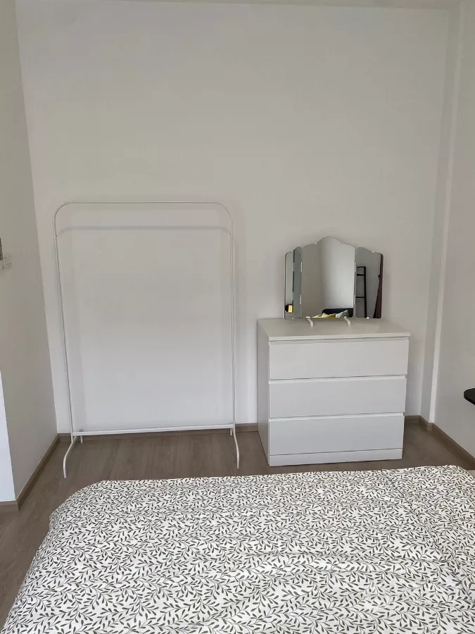 联排别墅 出租在Prawet, Bangkok - 简约卧室一角，五斗柜与衣架。