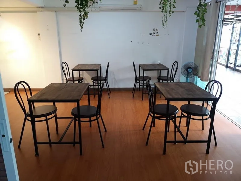 零售空间 出租在Khlong Toei, Bangkok - 用餐区摆放多张双人桌，旁为通往露台的推拉玻璃门