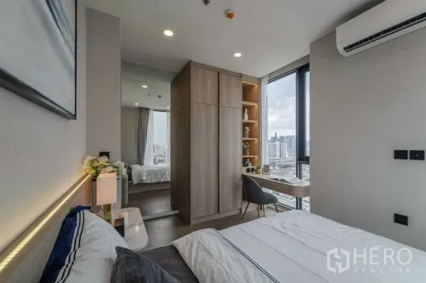 คอนโด ให้เช่าในPathum Wan, Bangkok - ห้องนอนกะทัดรัด มีตู้เสื้อผ้า โต๊ะทำงานมุมห้อง และหน้าต่างสูงวิวเมือง