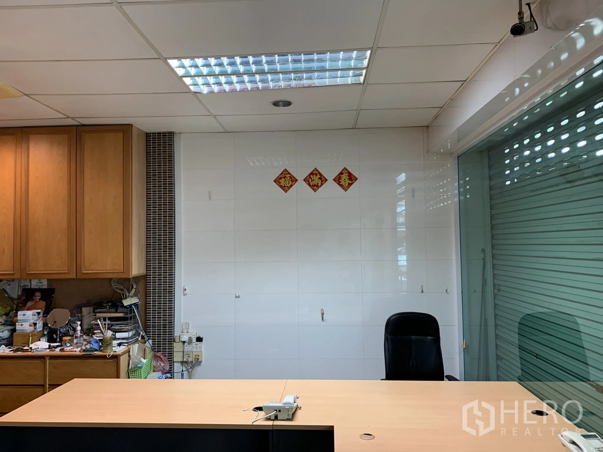 店屋 出售在Pathum Wan, Bangkok - 接待台区域，瓷砖墙、玻璃卷闸与内置储物柜。