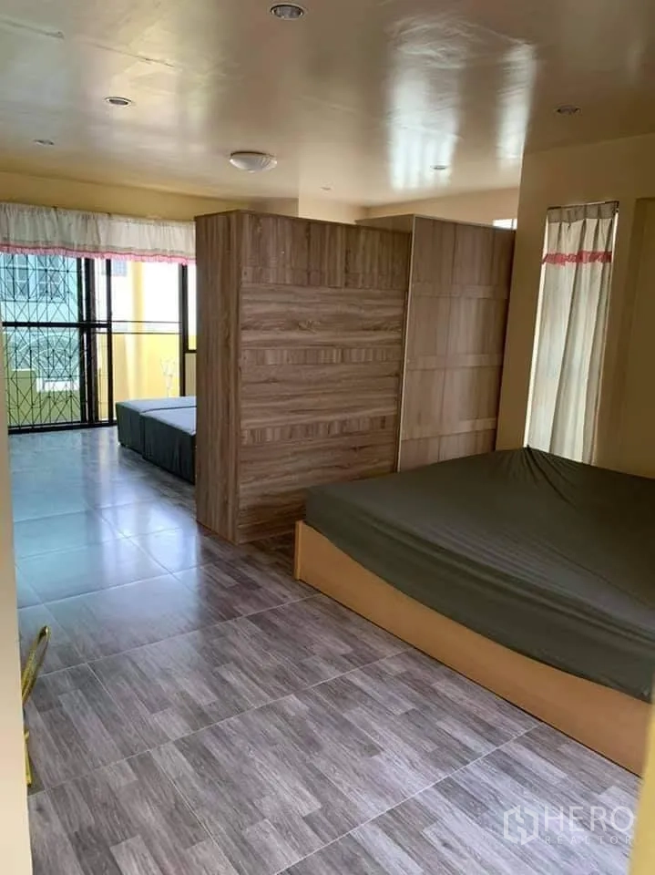 ทาวน์เฮาส์ ให้เช่าในPhra Khanong, Bangkok - ห้องนอนกว้าง ปูกระเบื้องลายไม้ มีผนังกั้นตู้เสื้อผ้าไม้ และทางออกสู่ระเบียง ในทาวน์เฮ้าส์ย่านบางจาก