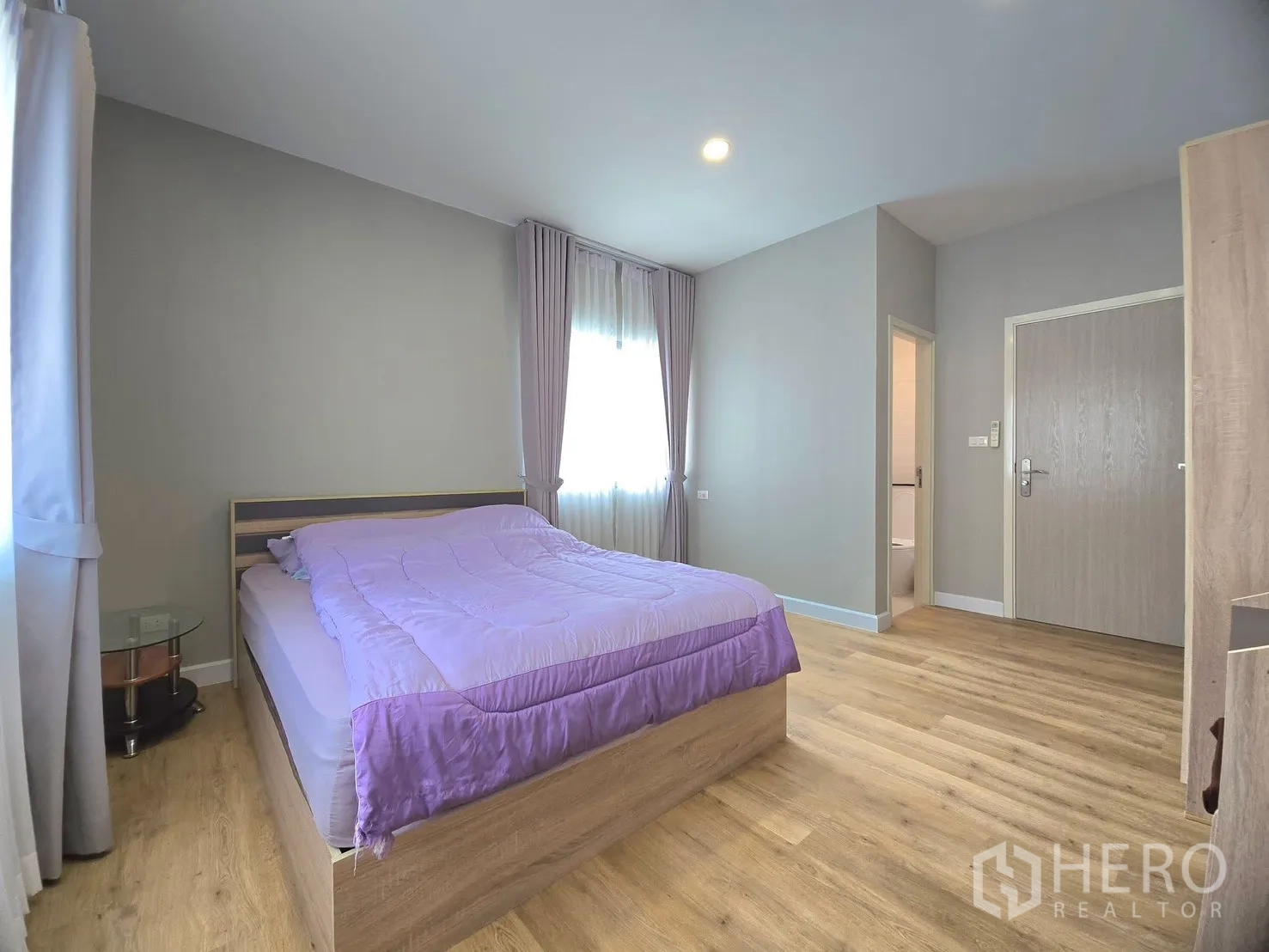 Detached House for rent in Lat Krabang, Bangkok - Furnished bedroom with double bed, curtains and wood floors.