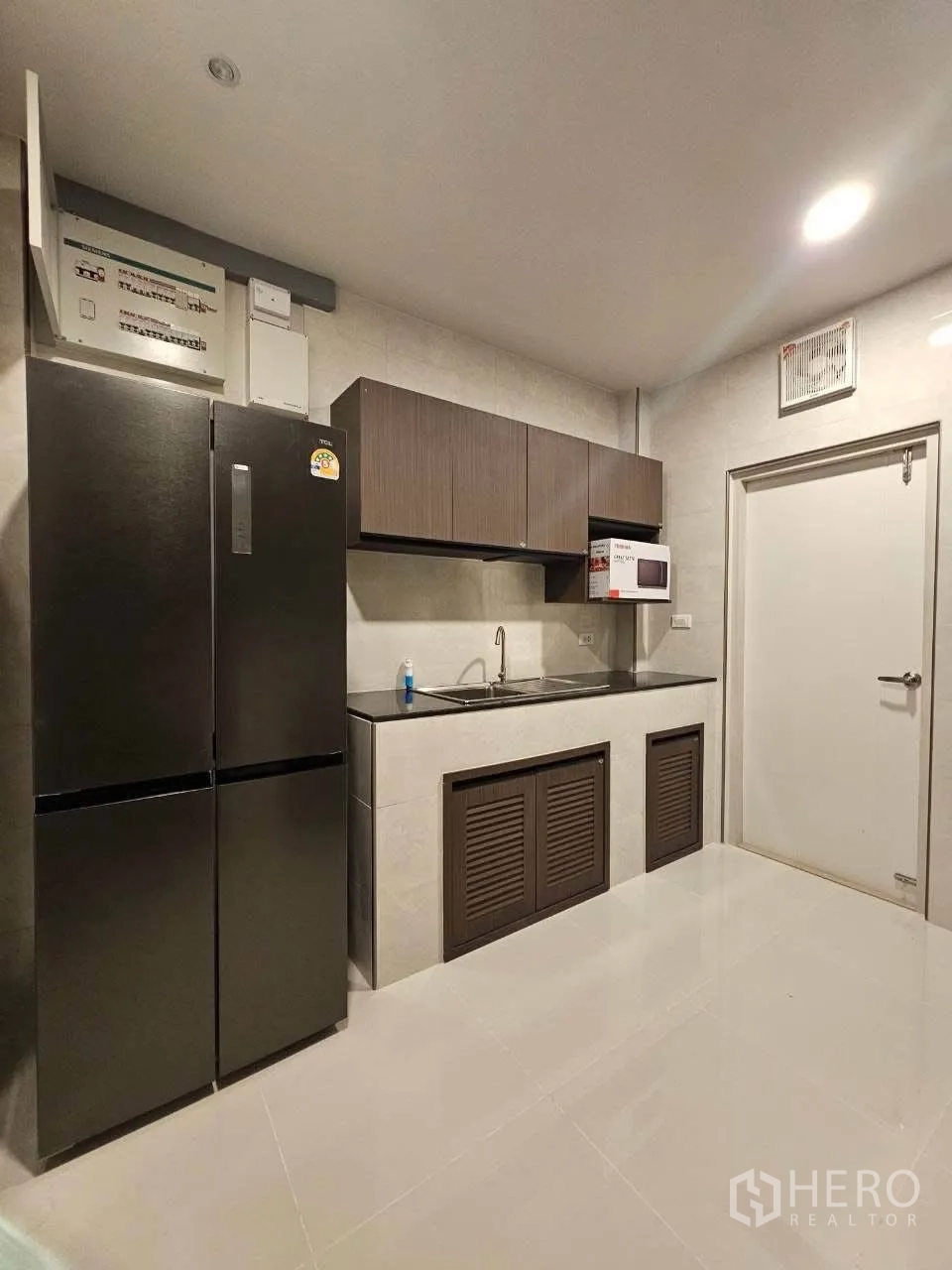 独栋房屋 for rent or sale in Bang Phli, Samut Prakan - 厨房一角，双开门冰箱、水槽及上方橱柜。