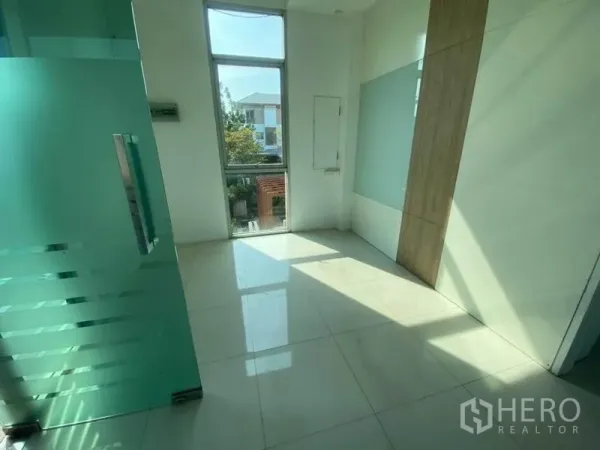 零售空间 出租在Bueng Kum, Bangkok - 采光良好的室内空间，磨砂玻璃门、落地窗与亮面瓷砖地面。