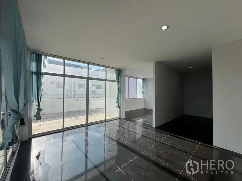 Warehouse for rent or sale in Chon Buri - Bright top-floor room with floor-to-ceiling windows opening to a terrace.