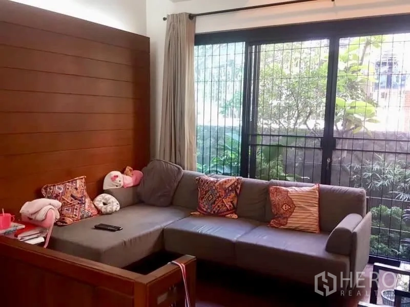 สำนักงานที่บ้าน ให้เช่าหรือขายในBang Rak, Bangkok - มุมนั่งเล่นสบาย โซฟาเข้ามุมสีเทา ประตูกระจกบานเลื่อนมองเห็นสวน